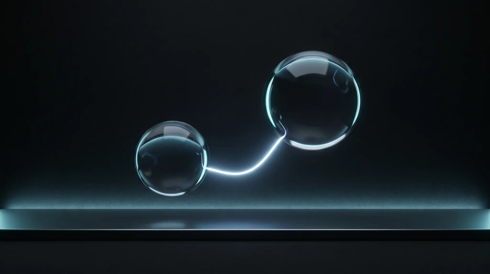 Two glass spheres exchanging a filament of light
